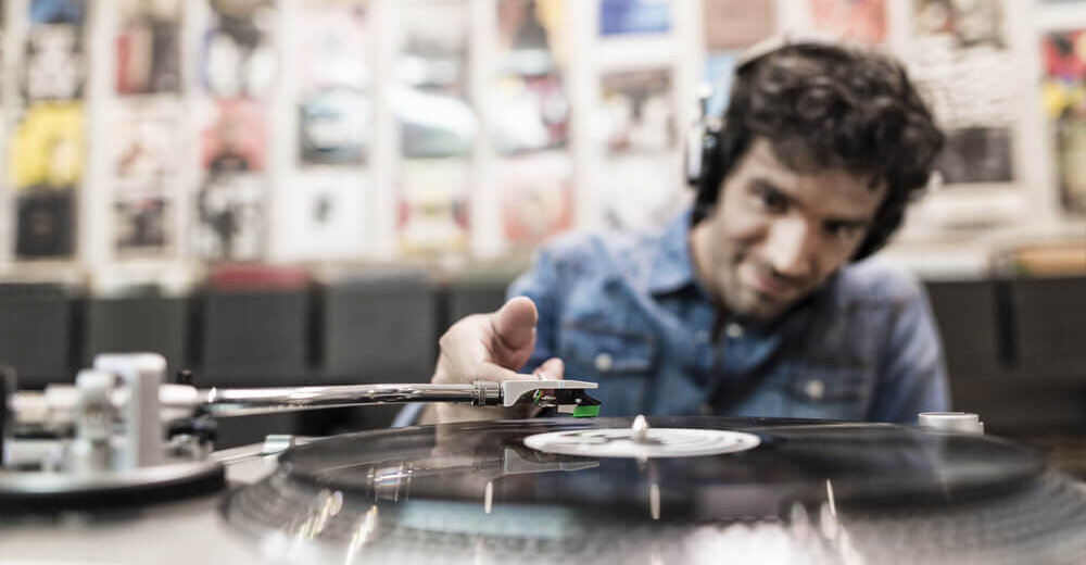 Image of a man playing a record on a turntable.