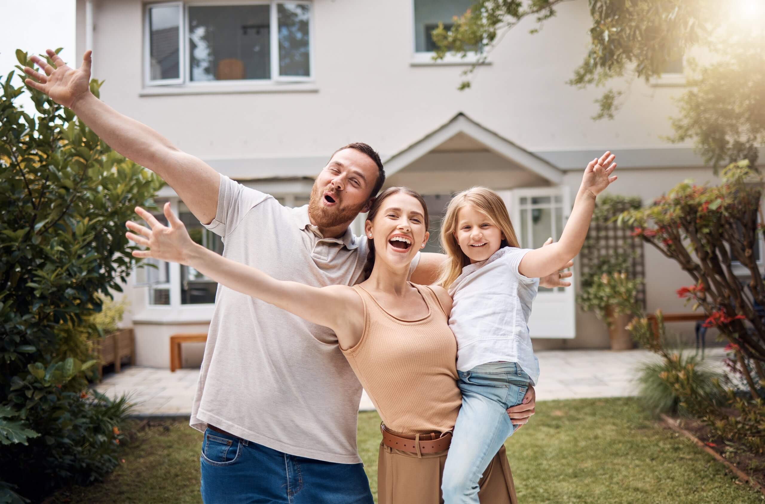 An image of a happy family including a dad, mum and child outside their new home in Lydney.